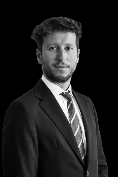Mario Oller, abogado, con traje oscuro y corbata de rayas, en blanco y negro