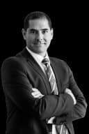 Andrés Pedreda, abogado, con traje oscuro y los brazos cruzados, en blanco y negro